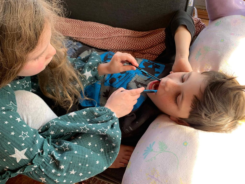 girl playing dentist on boy
