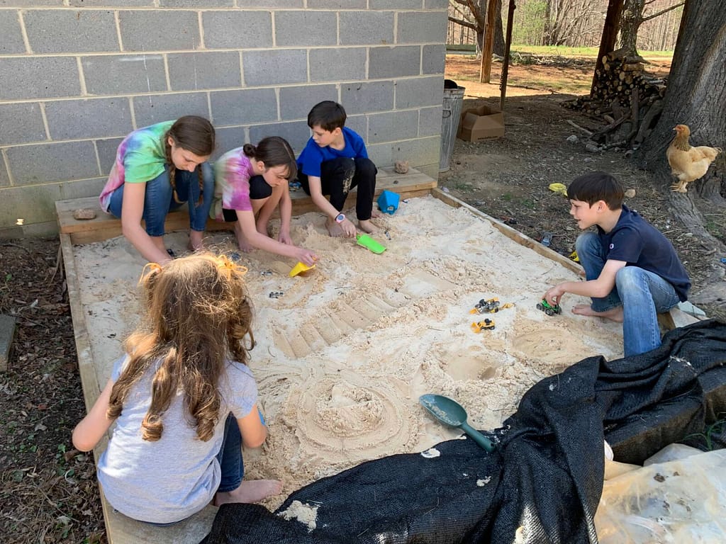 5 kids playing in the sandbox