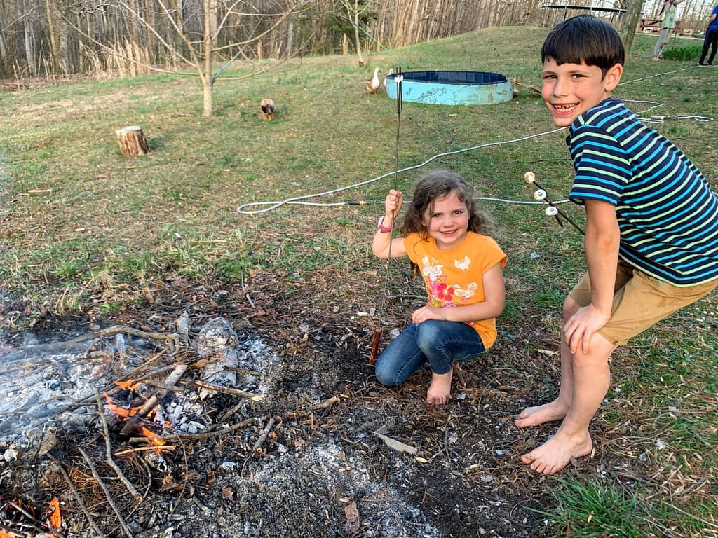 boy and girl roasting marshmallows in early spring