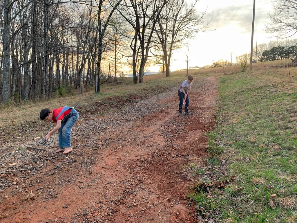 boys working on a dirt driveway
