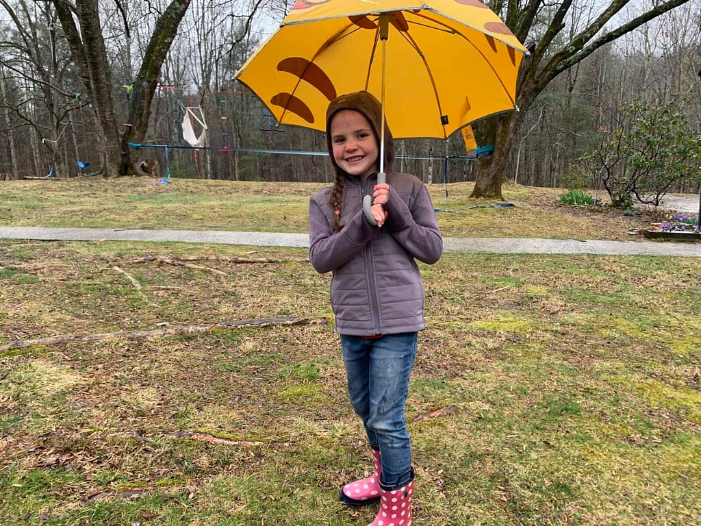6 year old with umbrella in the rain