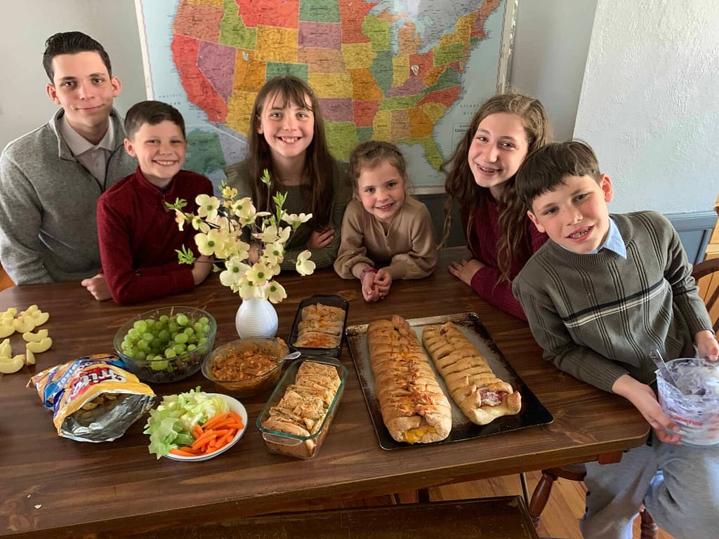 kids gathered around a table of snacks