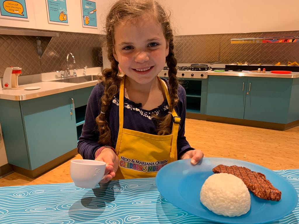 girl playing restaurant at a children's museum