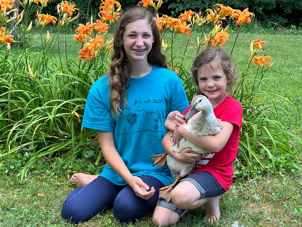 2 sisters holding a duck