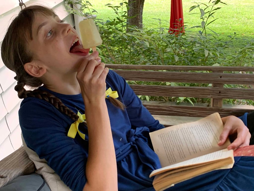 12 year old girl licking a lemonade popsicle