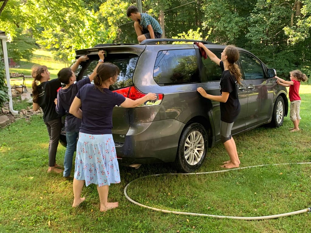 kids and mom wash a minivan
