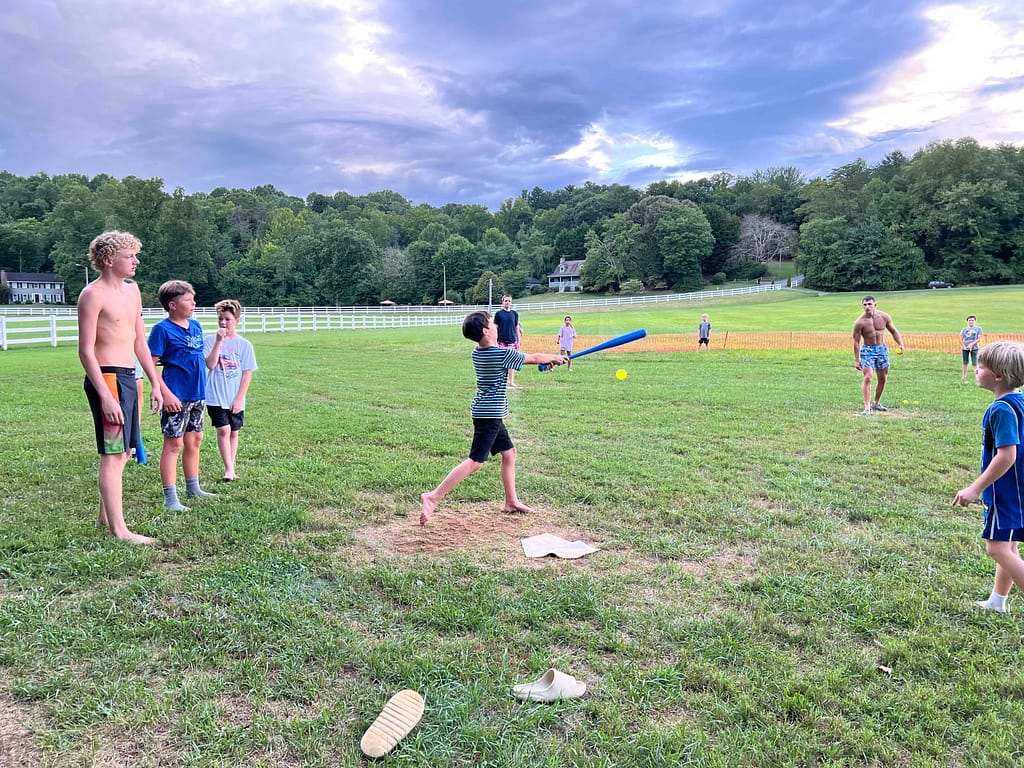 boy hitting the ball at a wiffle ball game