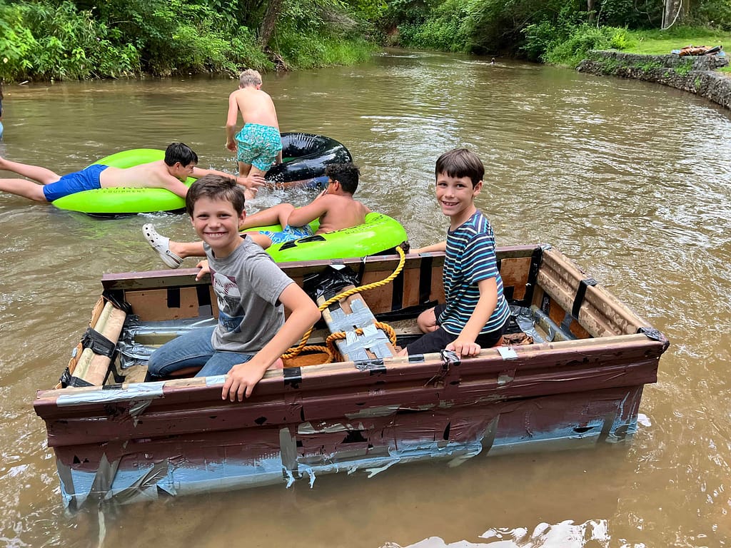 2 boys in a cardboard boat