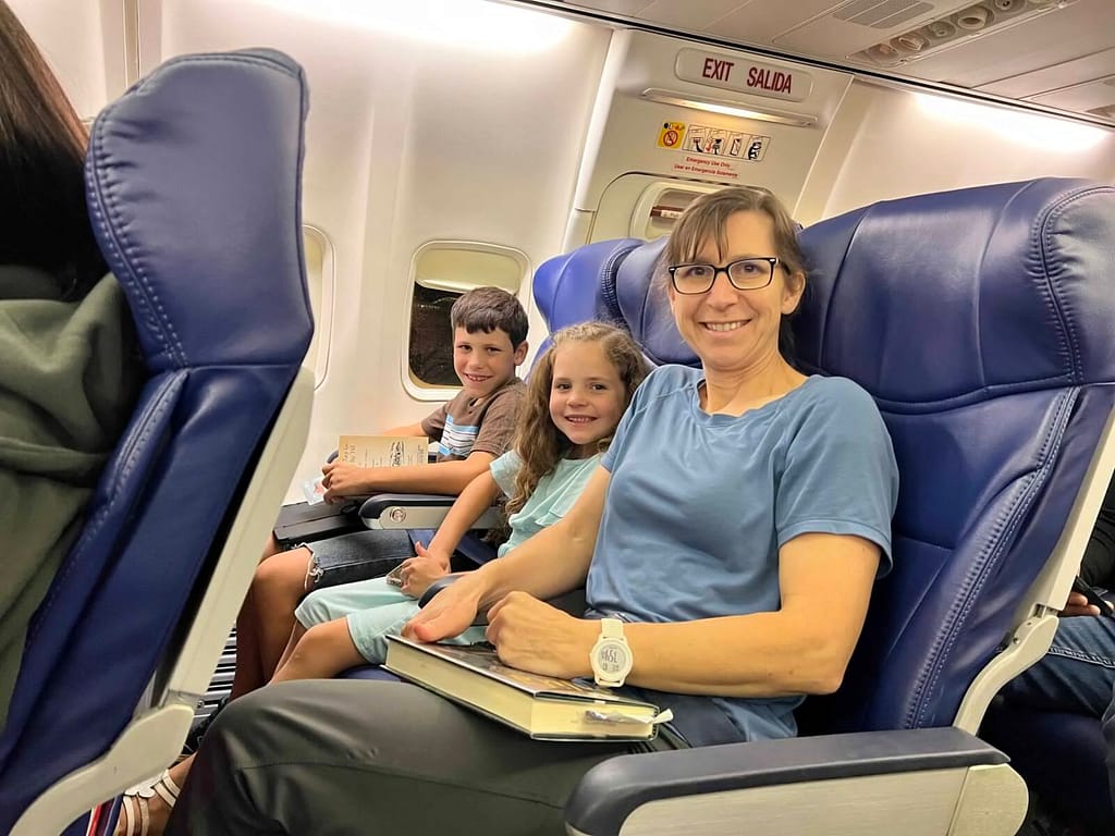 mom and 2 children on an airplane