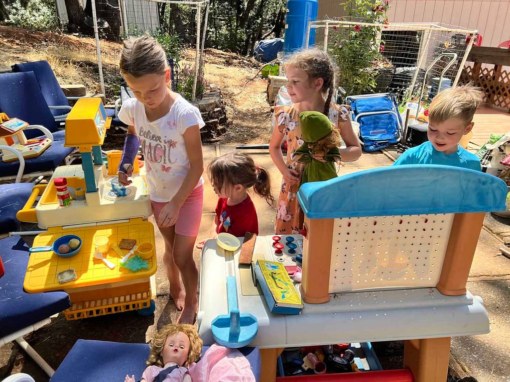 kids playing with a kitchen set outside