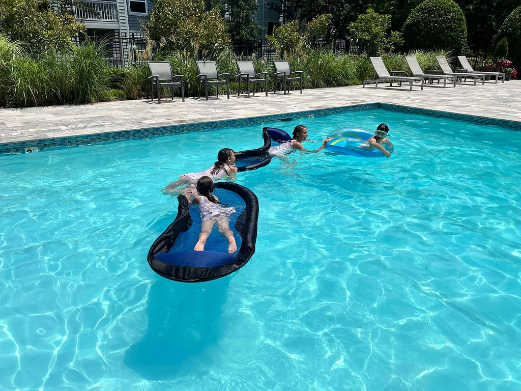 4 kids on a floatie train at the pool