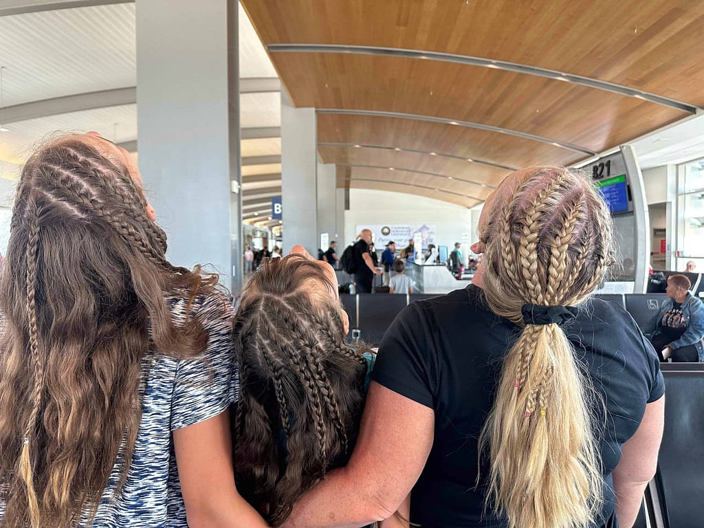 3 girls showing off their heads full of braids