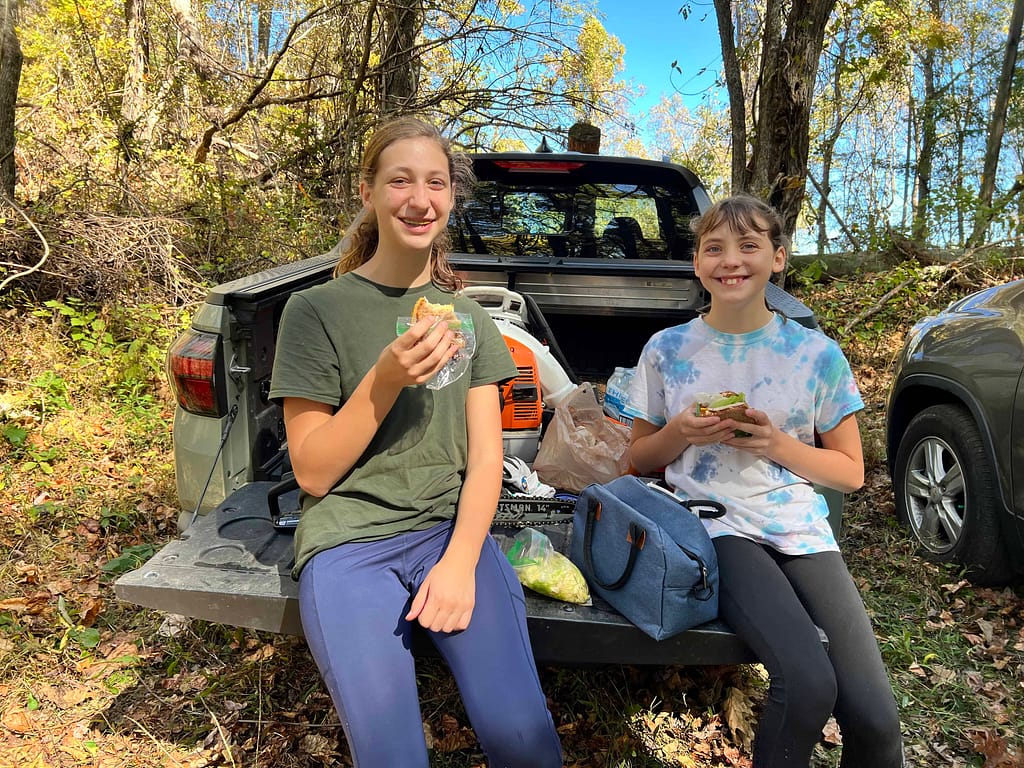 2 sisters eating lunch on the back of a truck