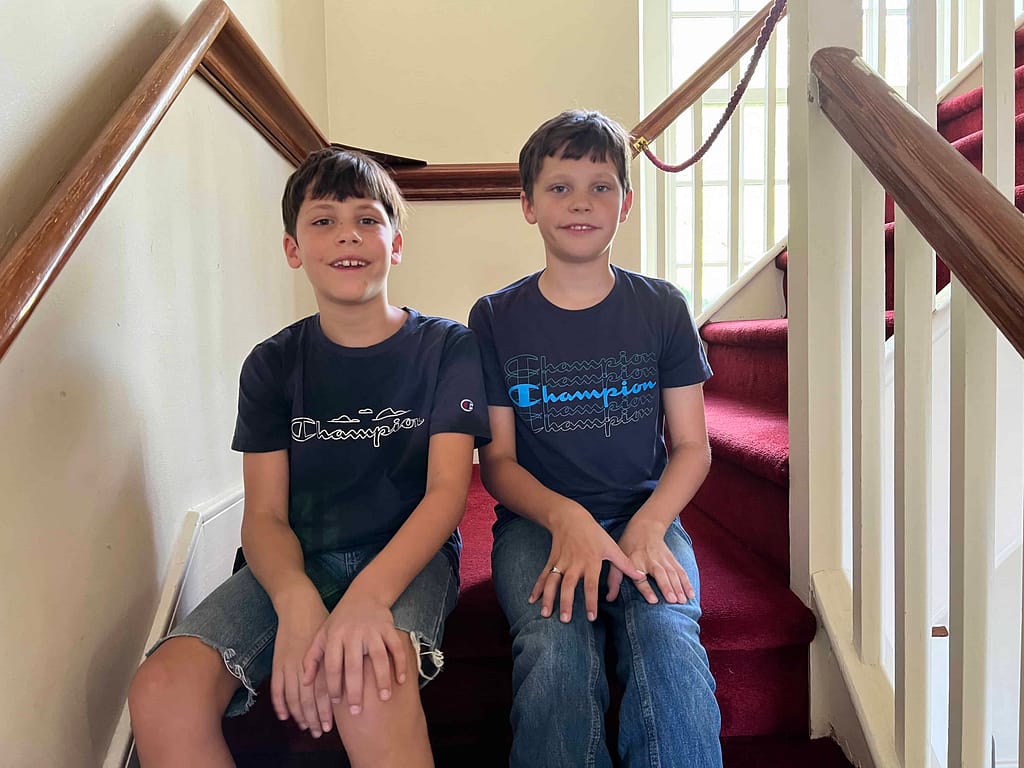 two little boys sit on the steps inside the first church of NC in Edenton