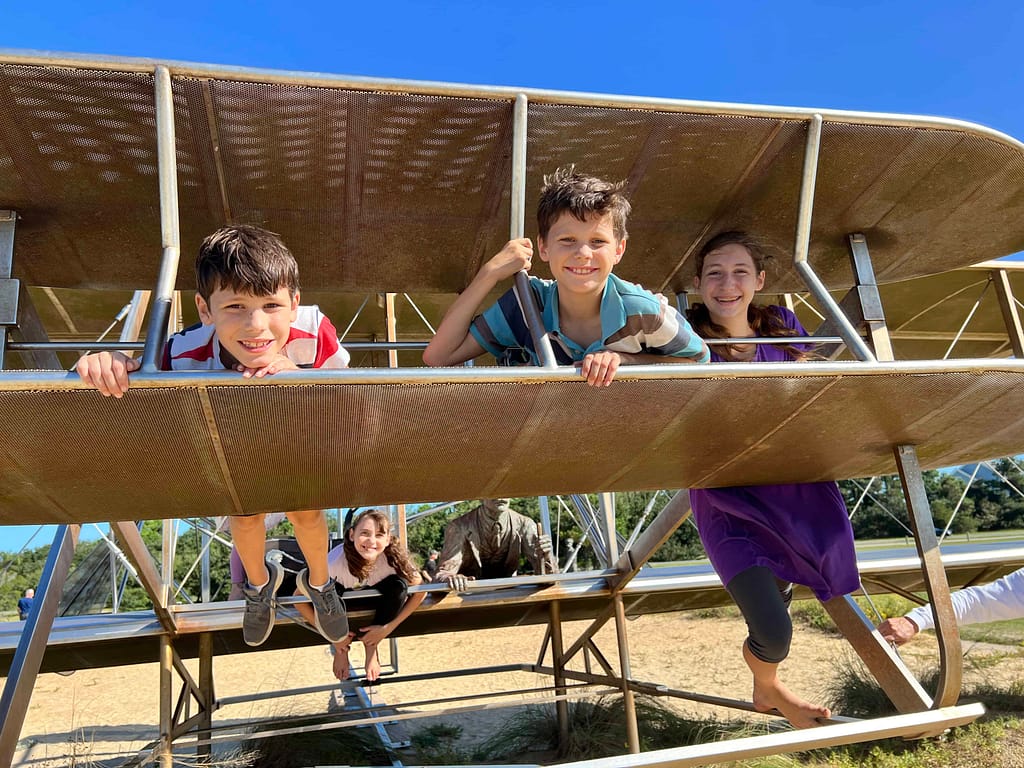 kids on wright flyer at kitty hawk