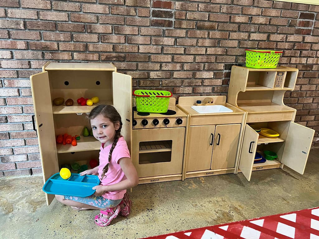 girl playing with a kitchen set in a museum