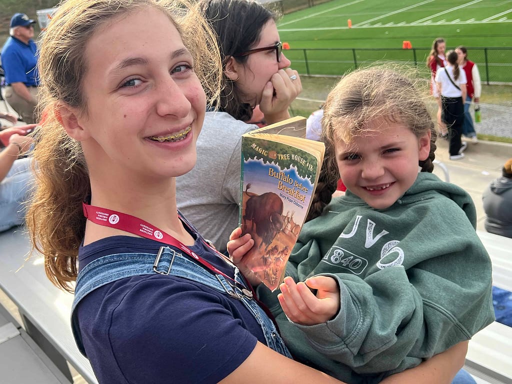 Sisters playing while watching a football game
