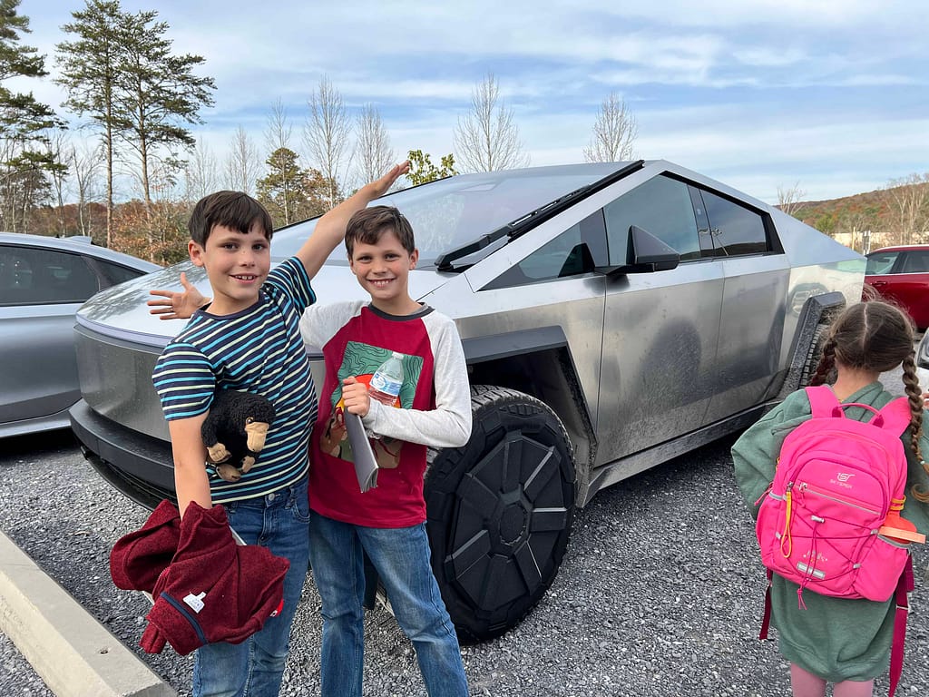 two boys in front of a cybertruck