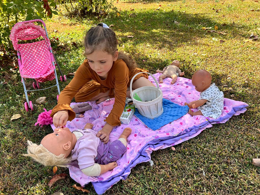 7 year old having a picnic with her dolls