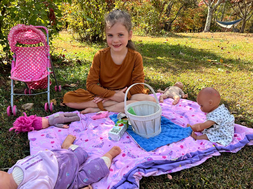 7 year old having a picnic with her dolls
