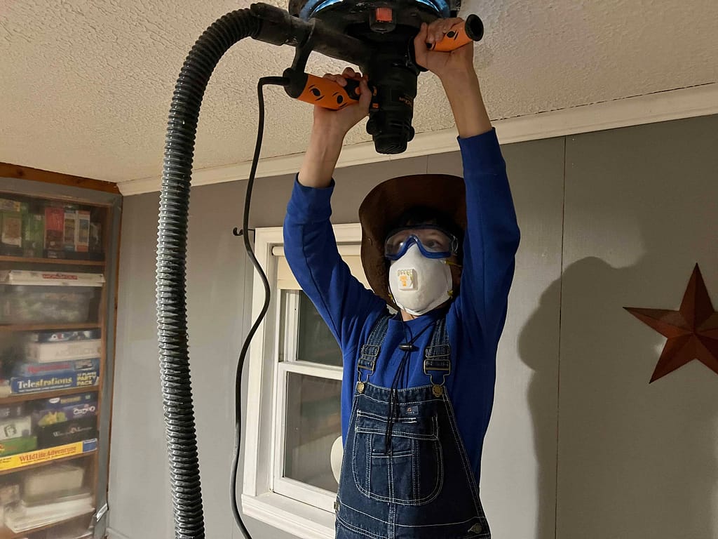 boy sanding popcorn ceiling