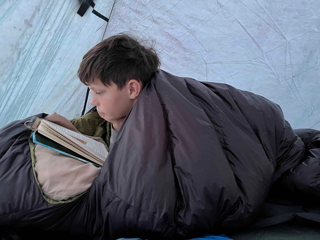 11 year old boy reading in a tent