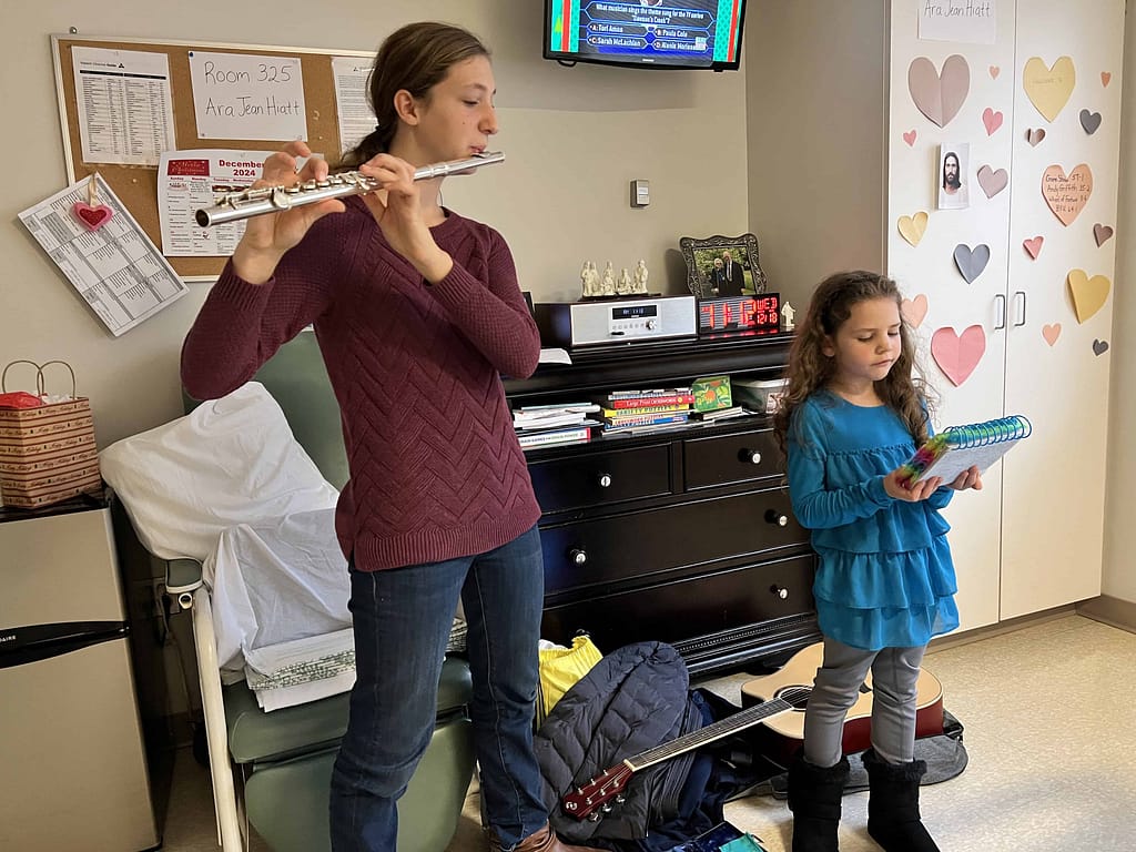 girls playing flute and singing at the hospital