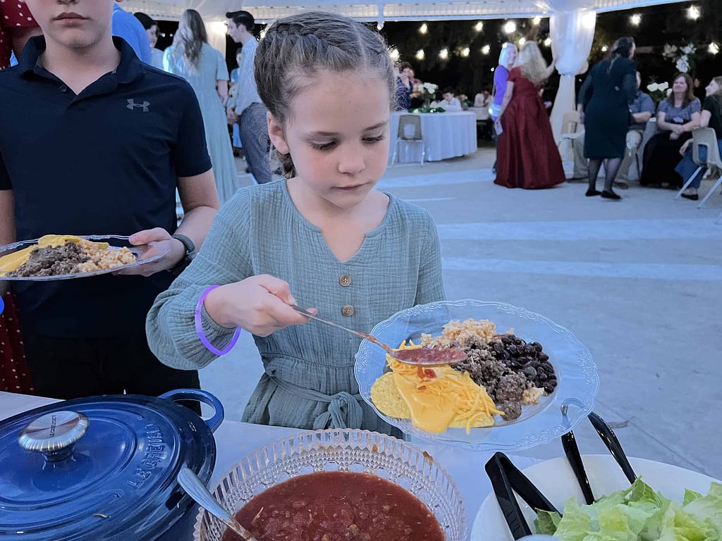 girl getting food at a wedding