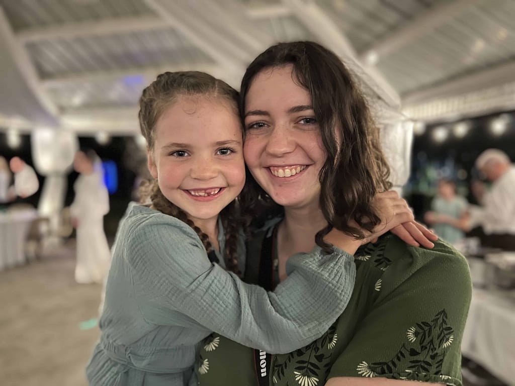 college sister and little sister smiling
