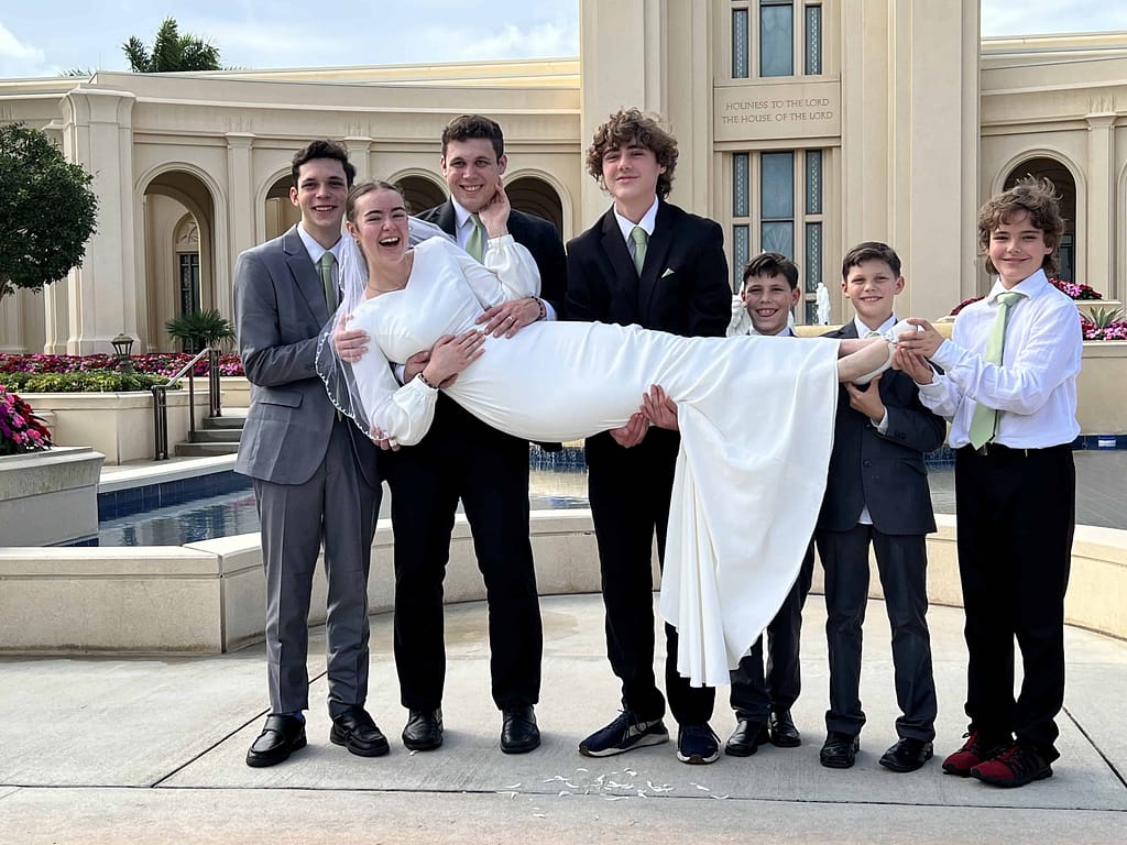 bride being held by her brothers and grooms brothers