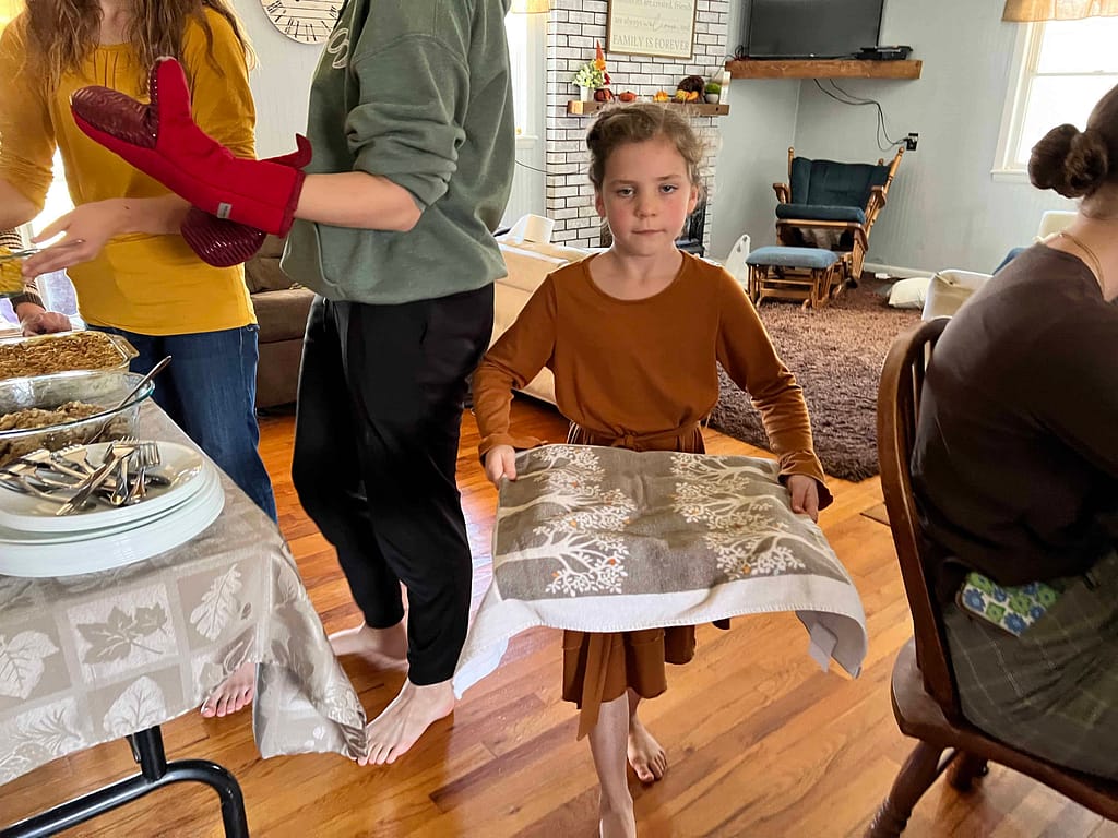 girl bringing rolls that have risen to the oven