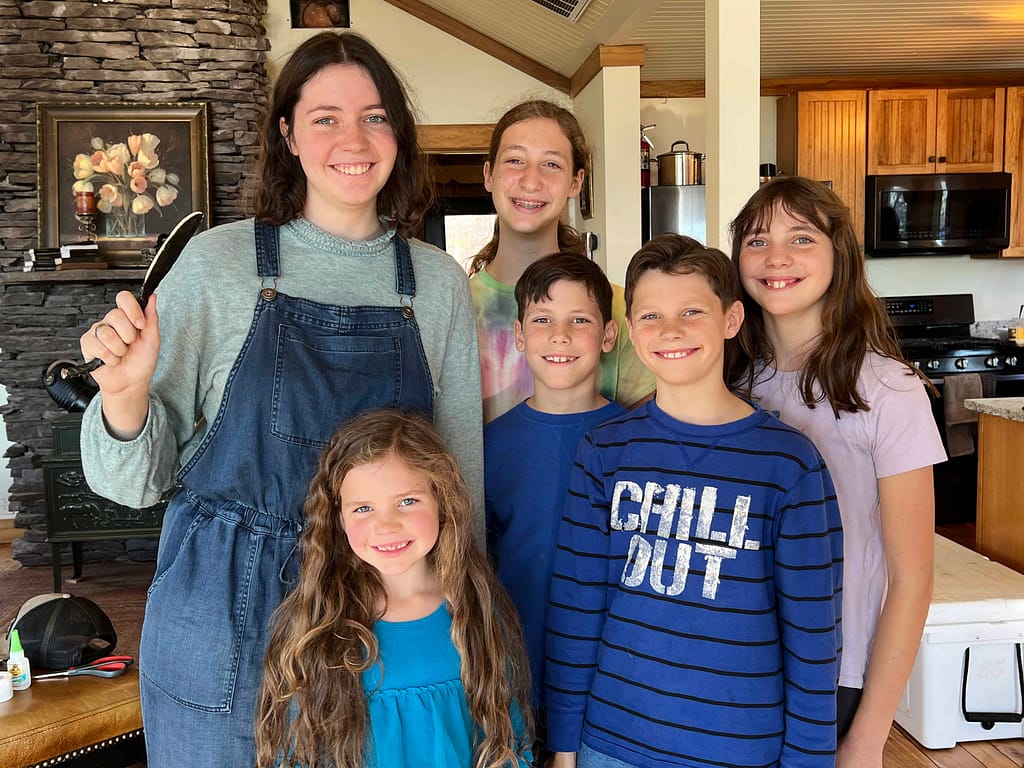 family showing a knife they made in a forge