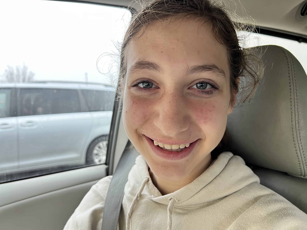 teen girl smiles after getting her braces off