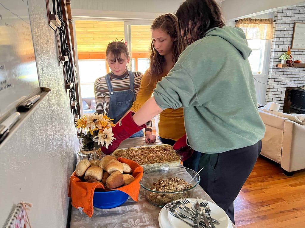 kids putting Thanksgiving dinner out
