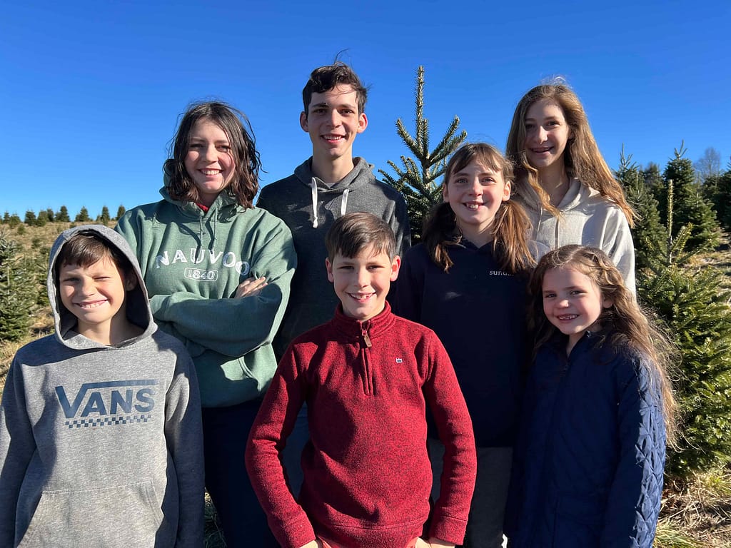 7 siblings at a Christmas tree farm