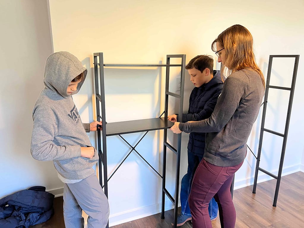 people helping put up shelves