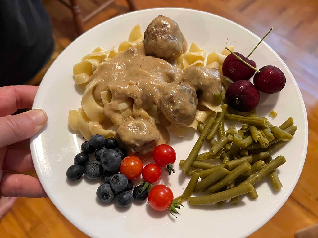 plate of healthy food: Swedish meatballs, berries, green beans, etc.
