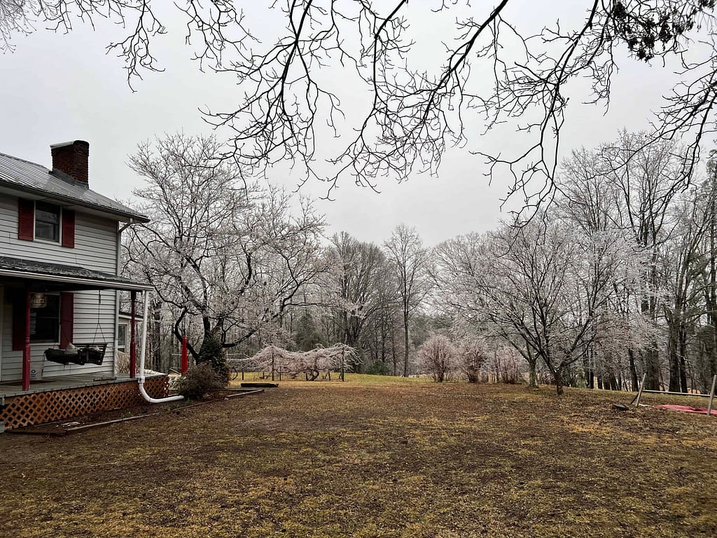 white farmhouse and yard in ice storm