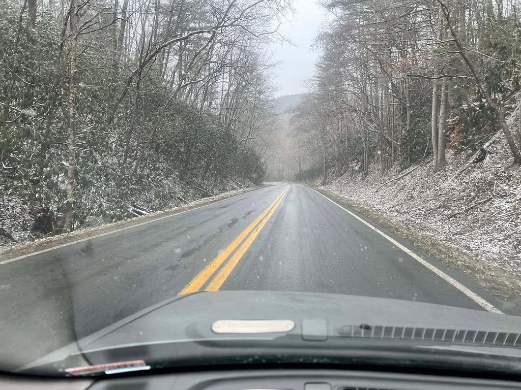 driving through a dusting of snow rural highway