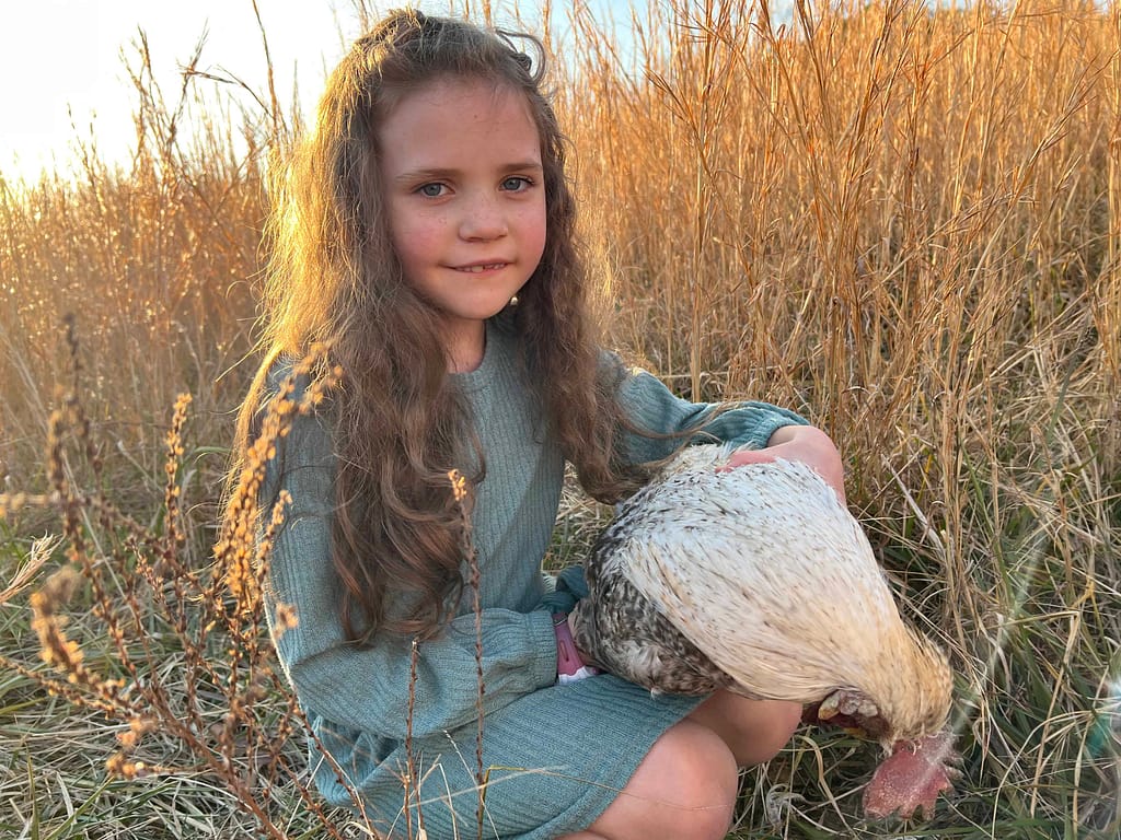 7 year old girl holding dead rooster