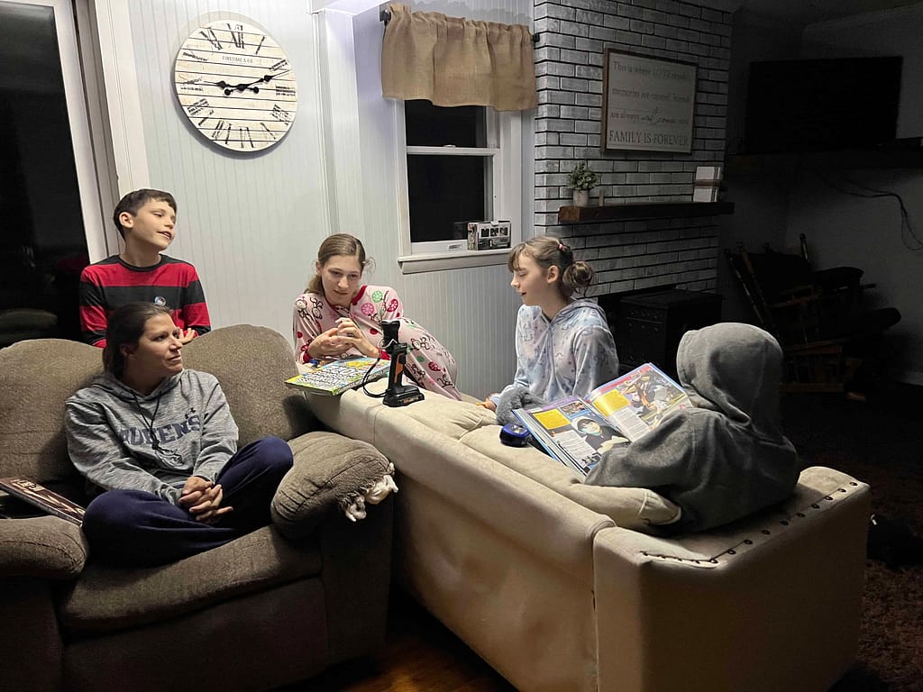 kids hanging out and reading by flashlight during power outage