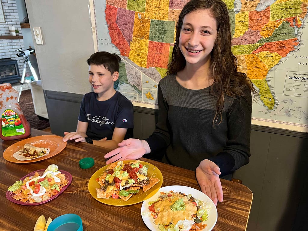 teen with two plates of nachos