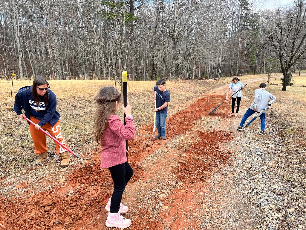 kids smoothing out a gravel driveway