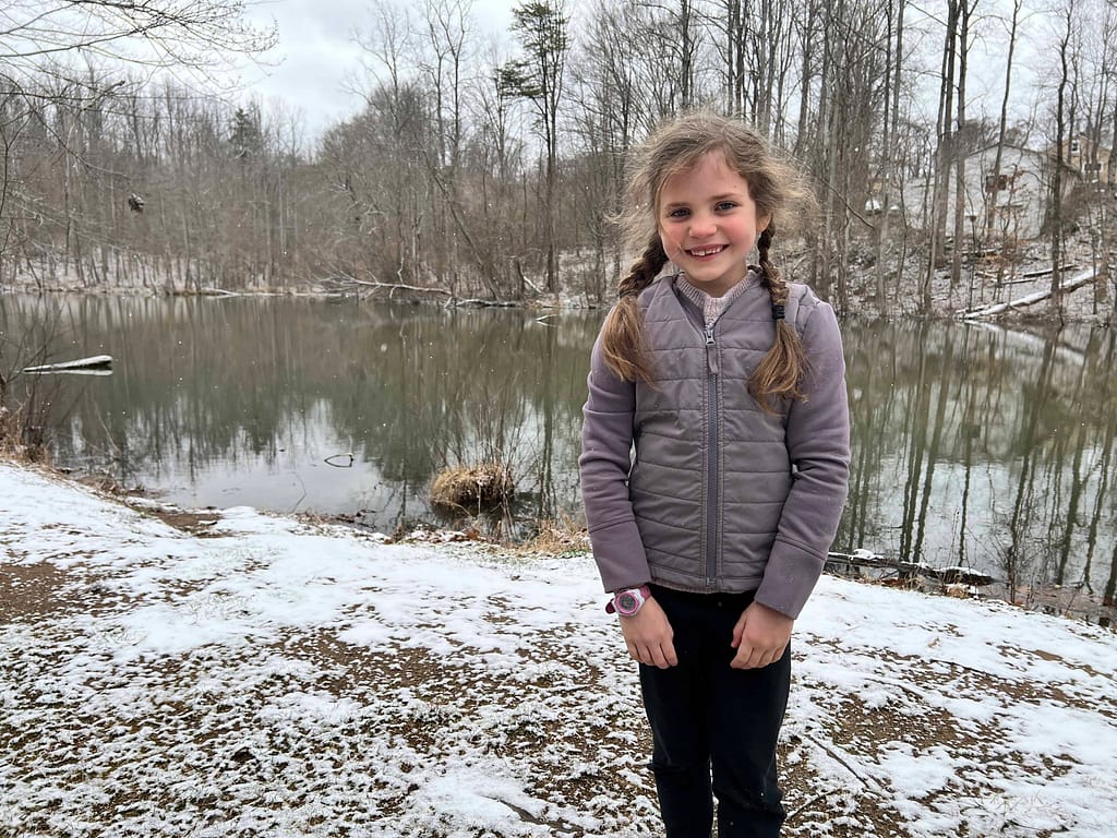 7 year old by a snowy pond