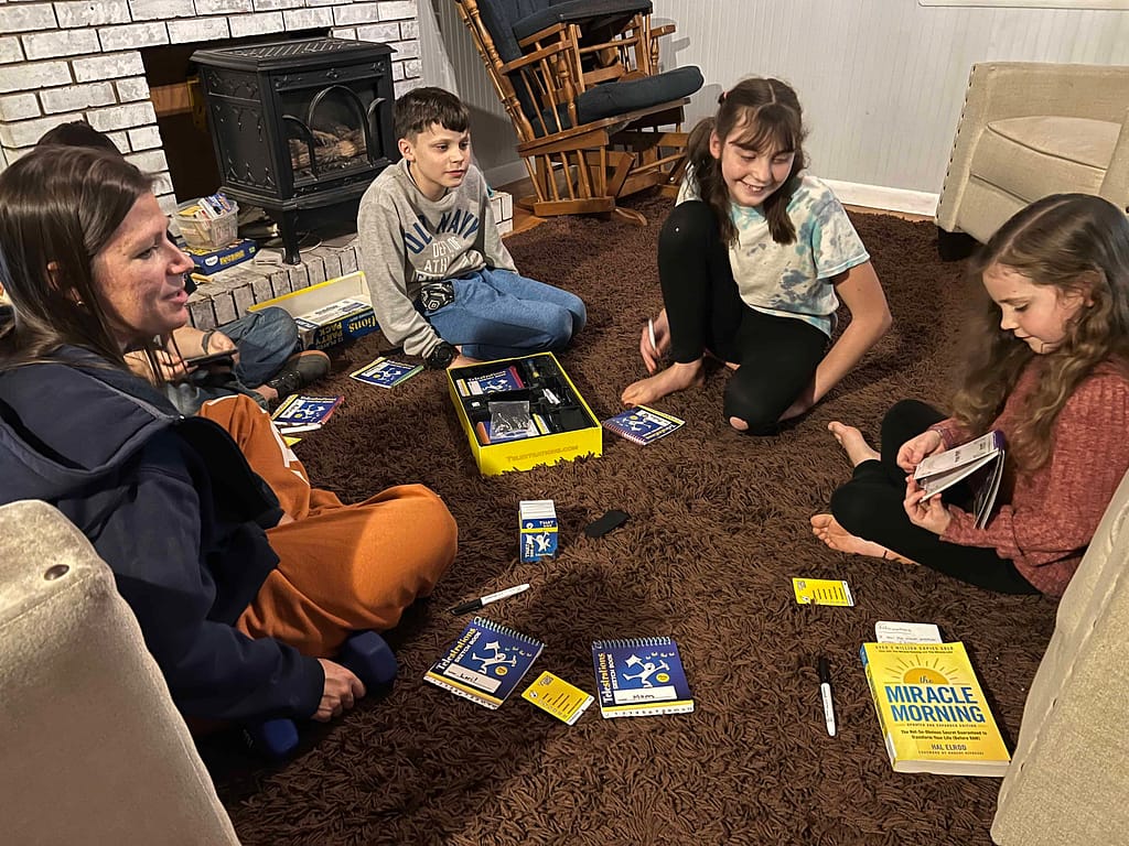siblings playing telestrations on the living room floor