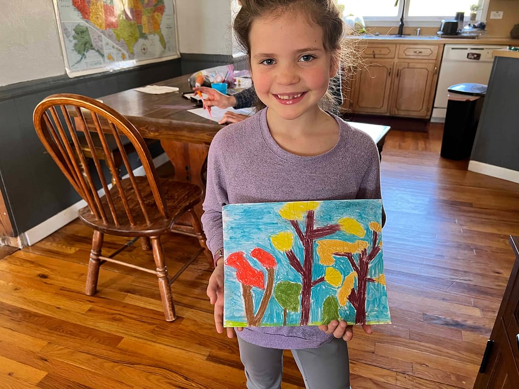7 year old girl showing painting of trees