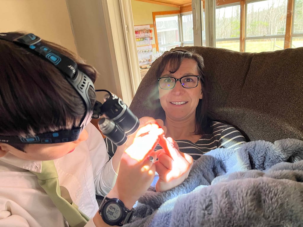 9 year old getting splinter out of mother's finger.
