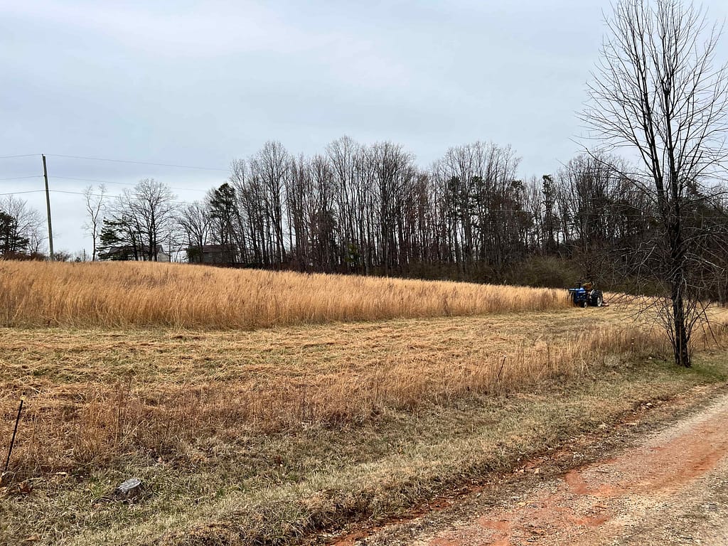 bush hogger mowing large brown field