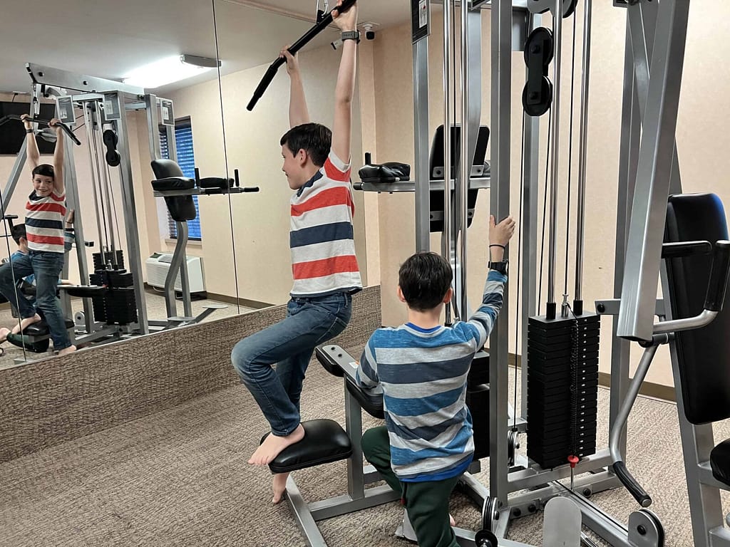 2 boys working out in weight room