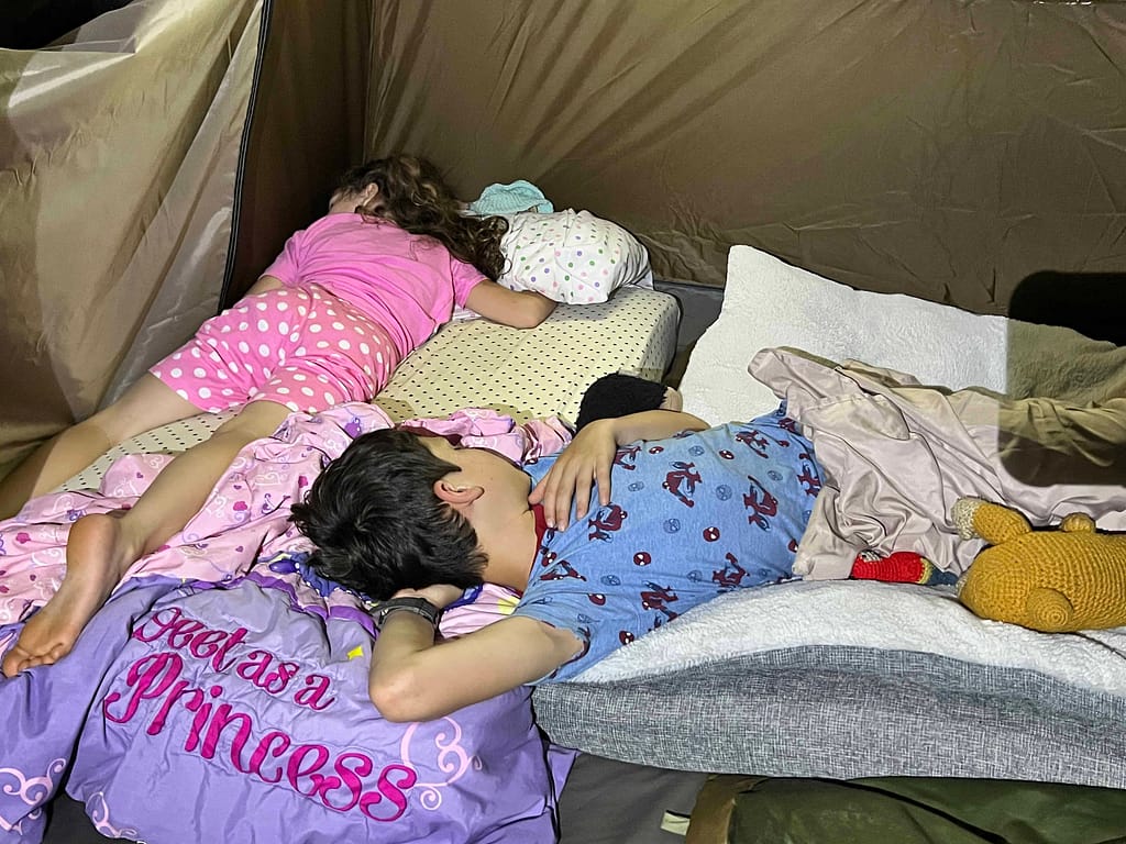 2 kids sleeping in a tent in the living room